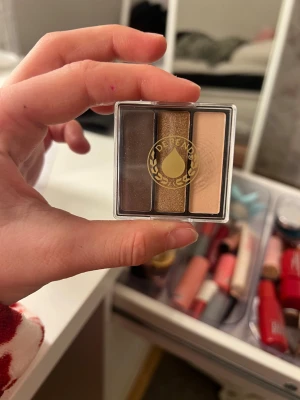 Depend ögonskuggspalett brun/guld/nude - Säljer en smidig ögonskuggspalett från Depend med tre nyanser: mörkbrun, skimrande guld och ljus nude. Perfekt för att skapa både naturliga och mer markerade ögonlooks. Kompakt förpackning som är lätt att ta med i väskan.