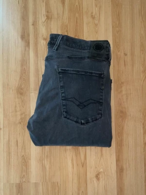 Replay Hyperflex Anbass jeans - Svarta Replay Hyperflex Anbass jeans med slim passform. Jeansen har stretchigt material för extra komfort och en snygg, mörk tvätt. OBS jeansen har hål vid skrevet och baktill på fickorna - se bild. Midja 40cm, längd 107cm. JAG SKICKAR EJ FLER BILDER NÄR JAG BÄR JEANSEN! för bättre inblick i passformen rekommenderar jag att googla på modellnamnet. För storleksguide kolla måtten noggrant då jeansen alltid kan vara uppsydda heller krympta och jag ej tar emot returer :) s5,2