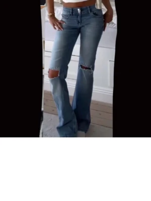 Ljusblå bootcut jeans med slitningar - Säljer ett par jättefina lågmidjade bootcut/flare jeans från Nelly! De är knappt använda alls och har inga defekter. De är i storlek 36 och har också lite stretch. Säg till om ni har några frågor!💗💗