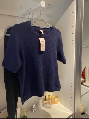 Mörkblå stickad tröja från Nelly - Säljer en mörkblå stickad tröja från Nelly i storlek S. Helt oanvänd med prislapp kvar