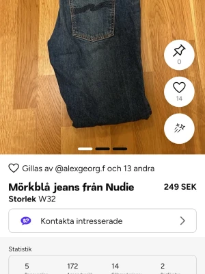 Mörkblå jeans från Nudie W32 - Säljer ett par mörkblå jeans från Nudie i klassisk modell med snygga detaljer på bakfickan. Jeansen har en rak passform och är tillverkade i slitstarkt denimmaterial. Perfekt för dig som gillar stilrena och tidlösa jeans.