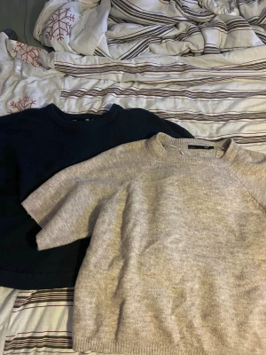 Två stickade tröjor från 157 XS/S - Säljer två stickade tröjor från 157, en i mörkblå och en i ljusbeige. Båda har rund hals och ribbade muddar. Perfekt för dig som gillar enkel och clean stil. Passar dig som vill ha en normal passform och mjukt material.