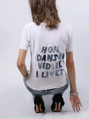Unik t-shirt med jeans text ”HON DANSAR VIDARE I LIVET” - Jätte fin och unik t-shirt med jeans text ”HON DANSAR VIDARE I LIVET”!!🪽  Tröjan är i storlek M, men hade passat någon som vanligtvis bär XS-L i toppar och tröjor beroende på hur tajt man vill att den ska sitta.  - Modellen är 175 cm lång och bär vanligtvis XS-S i överdelar.   T-shirten är i jättebra skick och har inga defekter (vad vi märkt)!!  Vid frågor eller funderingar - tveka inte att höra av dig🪽