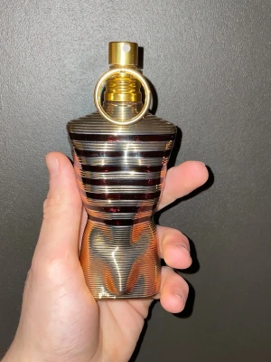 Jean Paul Gaultier le Malé elixir  - Snygg parfymflaska med metallisk finish och guldiga detaljer. Perfekt för dig som vill sticka ut och addera en cool touch till din samling. Passar dig som gillar trendiga accessoarer och modern stil.