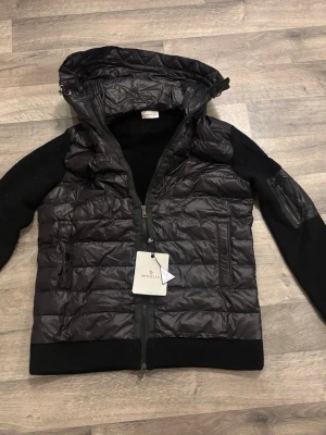  Moncler Cardigan - Säljer en svart cardigan/jacka  i storlek L, helt ny och aldrig använd. Snygg och stilren modell som funkar perfekt som lätt jacka eller i speciella tillfällen.  • Storlek: L • Skick: Helt ny • Färg: Svart • Quiltad front med stickade ärmar/rygg • Bra passform & hög kvalitet • NFC-tag finns och fungerar • Säljes pga för stor för mig (182 cm / 55 kg)