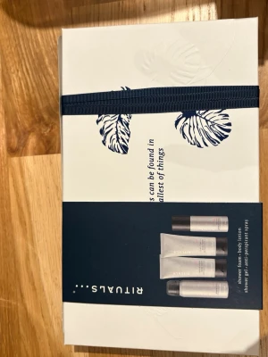 Rituals presentbox med hudvård - Snygg presentbox från Rituals med mörkblå och vit design, innehållande shower foam, body lotion, shower gel och anti-perspirant spray. Produkterna kommer i stilrena tuber och flaskor i silver och svart. Perfekt för dig som gillar lyxig hudvård med fräsch doft.
