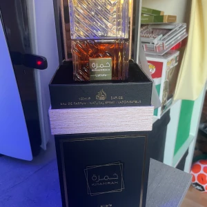 Lattafa Khamrah Eau de Parfum 100ml - Khamrah Eau de Parfum från Lattafa i en elegant flaska med ett geometriskt mönster. Doften har söta och varma kryddiga noter med inslag av vanilj, amber och kanel. Flaskan rymmer 100 ml och har en lyxig känsla med sin klara och bärnstensfärgade design. 98/100ml, kan också gå med på byten. Säljer pga behöver en sommar parfym.Skickar inom 1 dag. Om ni undrar nått så är det bara att fråga😁