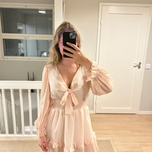 Rosa klänning - Fin rosa klänning med rosett. Använt en gång men har dock en lite smuts fläck vid ärmen, har inte prövat tvätta men tror det lossar med tvätten.