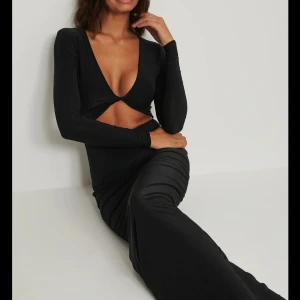 Brun långklänning med cut out - Supersnygg brun långklänning med djup v-ringning och cut out-detalj under bysten. Prislapp kvar!!