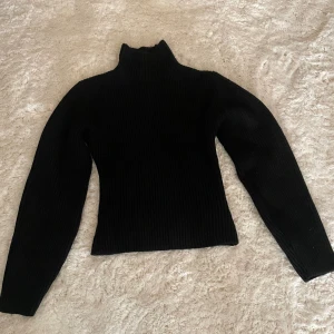 Svart ribbad polotröja stickad - Säljer en svart stickad polotröja med ribbad struktur. 