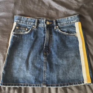 Jeanskjol med gula ränder - Snygg oanvänd kort jeanskjol med raka linjer och gula ränder på sidorna. 💛🐝