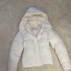 Vit pufferjacka från Calvin Klein Jeans - Fräsch Calvin Klein jacka i bra kvalité!! Storlek XS och passar nog både XS/S/XSS, inga fläckar eller hål så den är i bra skick!