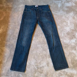 Levi's 501 blå jeans straight fit - Klassiska Levi's 501 jeans i mörkblå denim med raka ben och knappgylf. Tidlösa och perfekta vid alla tillfällen! Jeansen är i mycket bra skick, om ni har frågor är det bara att kontakta mig!