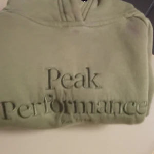 Olivgrön hoodie från Peak Performance - Säljer en olivgrön hoodie från Peak Performance med broderad logga framtill. Tröjan har huva och är tillverkad i mjukt material som känns skönt mot huden. Perfekt för dig som gillar en avslappnad och sportig stil. Köpte för 1200 finns i Grums tar bara cash