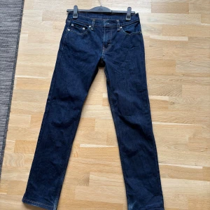 Levi's 511 mörkblå jeans W30 L32 - Säljer ett par Levi's 511 jeans i mörkblå tvätt. Klassisk femficksmodell med raka ben och snygga kontrastsömmar. Jeansen är i stretchigt denim och har en slim passform som sitter snyggt utan att bli för tighta. Perfekta för en clean och stilren look. Knappt använda då de snabbt blev urväxta. 