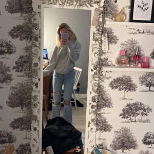 Ljusblå flare jeans Stradivarius - Säljer ett par ljusblå flare jeans från Stradivarius i storlek 32. Jeansen har hög midja, raka ben med utsvängd nederdel och snygga slitningar med hål på båda knäna. Klassisk femficksmodell i mjuk bomullsdenim.