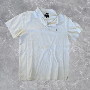 Boomerang Piké - Snygg vit pikétröja från Boomerang i klassisk modell med krage och två knappar. Tröjan har korta ärmar och en liten broderad logga på bröstet. Perfekt för en clean och fräsch look, tillverkad i mjuk bomull som andas.