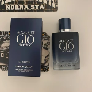 Acqua di Giò Profondo Eau de Parfum - Fräsch och modern parfym från Giorgio Armani, Acqua di Giò Profondo. Flaskan är stilren i mörkblått glas med silverdetaljer och matchande blå kork. Kommer i en elegant blå kartong. Perfekt för dig som gillar marina och fräscha dofter.