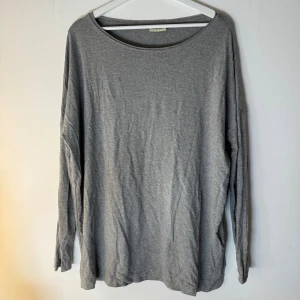 By Malene Birger tröja  - Grå långärmad tröja med en bred, rund halsringning. Den har en avslappnad passform och är enkel i sin design. Storlek M. 