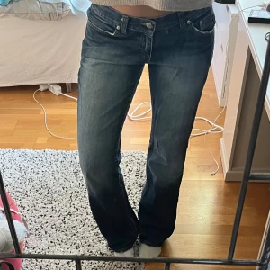 Emporio Armani AJ jeans med strassdetaljer - Säljer ett par blå jeans från Emporio Armani med låg midja och raka ben. Baksidan har AJ-logga och örn broderad med strass på bakfickorna. Fint skick, några av paljetterna på fickorna har gått av (se bild) men inte något som syns mycket alls. Perfekta till alla tillfällen och supersköna. Midjemått 42 cm, innerbenslöngd 80 cm