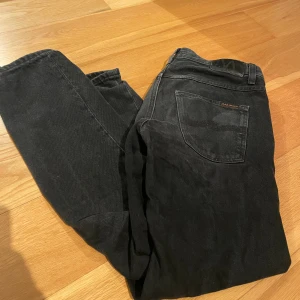 Svarta Nudie Jeans - Svarta nudie jeans i modell gritty jackson . Jeansen har en rak/slim passform. W32 L30