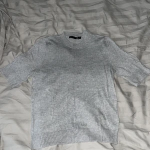Grå tröja från Lager 157  - Snygg grå tröja från lager 157 i storlek XS. Tröjan har korta ärmar, ribbad halsringning och muddar vid ärmslut och nederkant. Det är mjukt material.