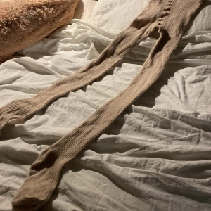 Beige ribbade strumpbyxor i bomullsblandning - Beige ribbade (5 bilden) strumpbyxor i ekologisk bomullsblandning. De har en mjuk och stretchig känsla, perfekt för dig som vill ha något bekvämt och stilrent. Dom har en liten defekt under fötterna, där dom är lite noppriga men bara där (som ni ser på 4 bilden)💕 bara använt några gånger 