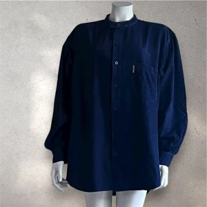 Armani mörkblå manchester henley  - Snygg mörkblå henley-skjorta från Armani i mjuk manchester. Skjortan har ståkrage med dubbla knappar, bröstficka och avslappnad passform. Perfekt för dig som gillar klassisk stil med en twist.#armani