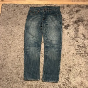 Levi's 501 blå jeans W32 L32 - Klassiska Levi's 501 jeans i skön tvätt. Modellen har rak passform, fem fickor och knappgylf. Finns lite tecken på användning och några lappar har ramlat av, sen så är de även ett gammalt par är jag rätt säker på. Skriv vid funderingar!