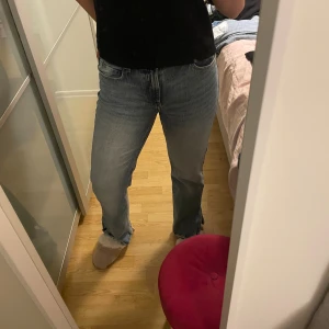 Blå raka jeans från Bershka - Säljer ett par klassiska blå jeans från Bershka i storlek 36. Jeansen har rak passform, normal midja och är tillverkade i bomull. De har fem fickor och stängs med dragkedja och knapp. Perfekta till en avslappnad stil.