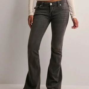 Grå bootcut jeans från True Religion - Snygga grå jeans från True Religion med bootcut passform och klassiska detaljer. Jeansen har fem fickor, markerade sömmar och logopatch bak. Tillverkade i stretchig denim för en bekväm känsla och cool look.