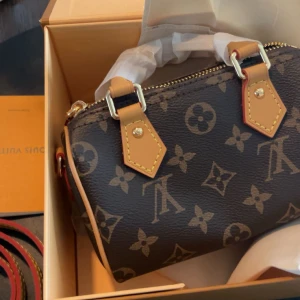 Louis Vuitton monogram handväska - Säljer en ikonisk Louis Vuitton handväska i klassiskt monogrammönster. Väskan är brun med beiga detaljer och har guldfärgade metalldelar. Den är tillverkad i skinn och har både handtag och axelrem. Perfekt storlek för det viktigaste.  Den är 16*10*7.5 cm. Speedy nano. Boxen sålde jag för sig själv för några månader sen då jag trodde jag skulle vela behålla väskan. Har fått den i present och har ingen användning utav den. Vid fler bilder hör av er. Dustabag MEDFÖLJER 💖