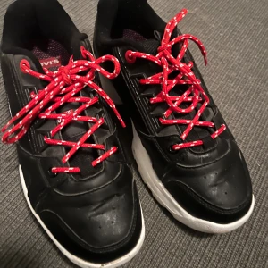 Svarta Levi's sneakers med röda snören - Svarta chunky sneakers från Levi's med vit sula och röda snören med vita detaljer. Skorna har tydlig logga på sidan och baksidan samt detaljer i svart syntetmaterial. Perfekta för dig som gillar en sportig och streetinspirerad look.