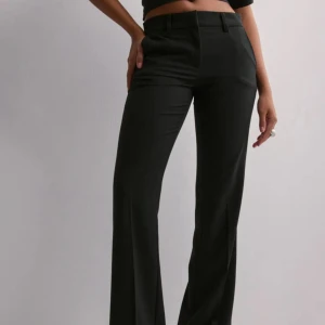 Svarta lågmidjade kostymbyxor Nelly - Pris kan diskuteras. Snygga svarta kostymbyxor från Nelly med låg midja och bootcut-snitt. Byxorna är använda endast en gång. Storlek xs men passar s 