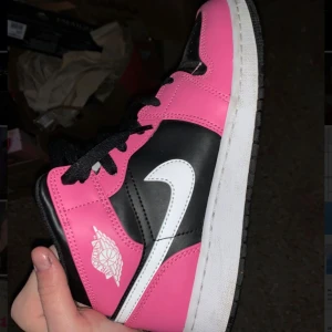 Nike Air Jordan 1 Mid rosa och svart - Nike Air Jordan 1 Mid sneakers i en riktigt snygg färgkombo med rosa, svart och vita detaljer. Dom är i bra skick ser nästan oanvända ut köptes för ungefär 4000kr 