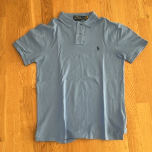 Ljusblå pikétröja från Ralph Lauren  - Ljusblå piké från Ralph, använd en gång så är alltså i nyskick. Storlek M, nypris 1300! Säljer för 499!