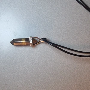 Halsband med brun kristallhänge - Hänge med halsband i läder liknande material samt liten kedjedel. Smyckes storlek: ca 41mm x 13mm  Kedjestorlek: ca 45cm - 50cm Observera att ditt smycke kan skilja sig något från bilderna på grund av naturliga material.🎈Fri frakt❤️