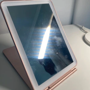 Sminkspegel (roséguld) - Aldrig kommit till användning. ”Reflection Perfection Led Lighted Mirror” som är köpt på Lyko. Rosé färgad med en touch display för att sätta på lampan och kan ändra mellan 3 ljus som är kallt, neutralt och varmt. Det går även att höja och dänga ljuset så det blir starkare och svargare genom att trycka ner knappen länge. Det krävs inga batterier utan går att ladda med tillhörande USB laddare. Perfekt att ha som smink spegel eller att ta med sig vid resa.  HÖJD: 19,3cm BREDD: 13cm Flexibelt 