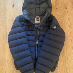 Svart pufferjacka från Colmar - Säljer en svart pufferjacka från Colmar med huva och dragkedja. Perfekt nu till kallare dagar. Storlek är 54 vilket motsvarar S-M. Skriv vid minsta fråga!