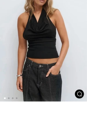 Svart halterneck topp - Jättesnygg svart halternecktopp med öppen rygg från Gina Tricot. Helt ny med prislapp. Slutsåld på hemsidan.