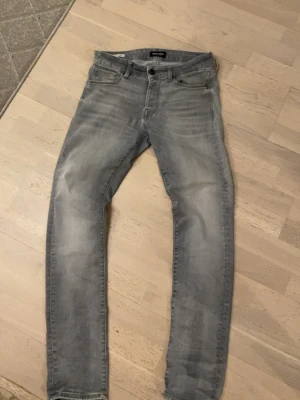 Ljusgrå slim fit jeans från Jack & Jones - Säljer ett par ljusgrå slim fit jeans från Jack & Jones i storlek 30/32. Jeansen har normal midja och smal passform, perfekta för en avslappnad och trendig look.