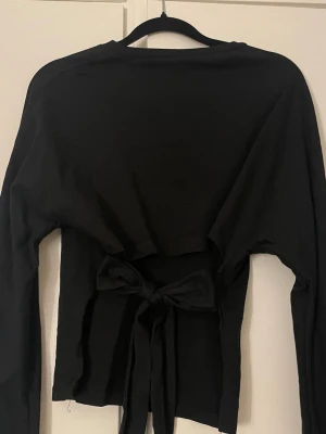 Svart långärmad topp med knyt i ryggen nelly - Inga defekter 