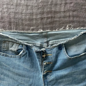 Ljusblå lågmidjade bootcut jeans - Väldigt snygga bootcut jeans med låg midja. De har en fransig kant vilket gör dessa sjukt snygga och unika. Materielet är jätte skönt och skulle säga att de är i storlek 38. Lappen är borta då vet inte märket och de är i mycket bra skick.