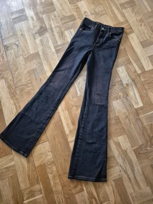 Mörka bootcut jeans med utsvängda ben - Snygga mörkblå jeans med bootcut och utsvängda ben. Klassisk femficksmodell med kontrastsömmar och knappstängning. Perfekta för dig som gillar en retroinspirerad look.Märke: DrDenim,Stl:32/S