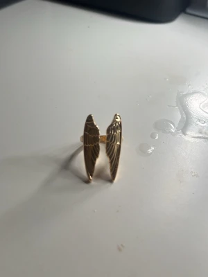 Guldfärgad ring med vingar - Aldrig använd, myckrt bra skick! Pris kan diskuteras! Köpte på en marknad i spanien!💕