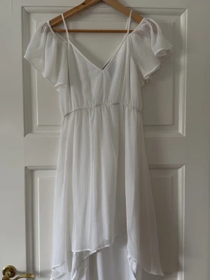 Vit klänning Nelly Trend  - Vit klänning i storlek XS, 100% polyester. Endast använd en gång. Passar perfekt till student, avslutningsmiddagar eller liknande.