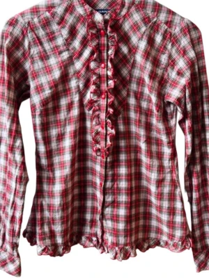 Rutig blus med volang från Gant - Röd, vit och svart rutig blus från Gant med långa ärmar. Blusen har volangdetaljer längs knäppningen framtill och vid fållen. Tillverkad i mjukt bomullstyg och har en klassisk krage. Perfekt för en trendig och avslappnad look.