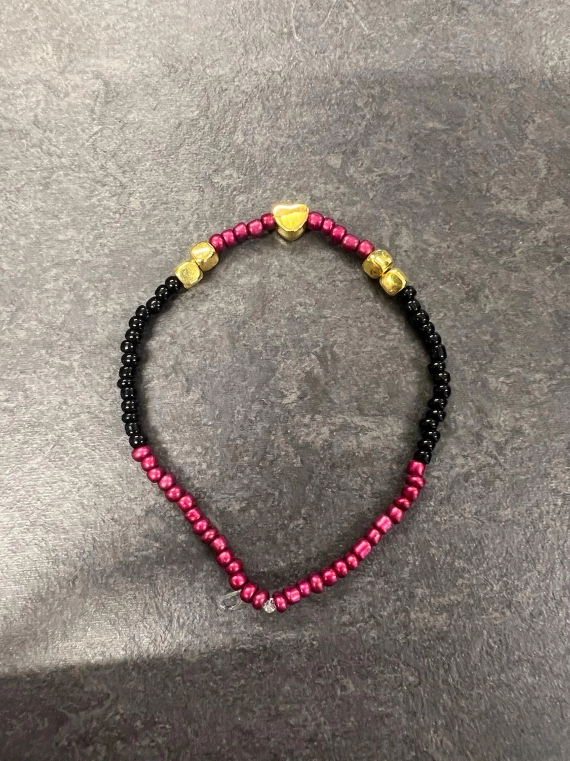 Armband i svart, röd och guld storlek L 