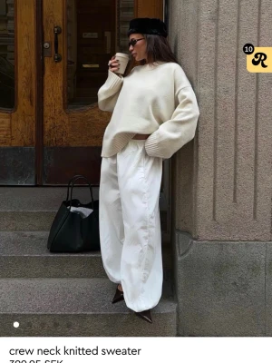 vit stickad tröja - Trendig vit stickad tröja med rund hals och avslappnad passform. Tröjan har breda ribbstickade muddar vid ärmslut och nederkant, samt droppade axlar för en modern look. Perfekt att styla med både jeans och vida byxor. säljer då den ej kommer till användning