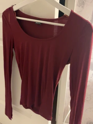 Vinröd långärmad topp Gina Tricot - Snygg topp från Gina, använd några gånger men den är nästan ny och den är i bra skick. Den har bra passform och slits vid ärmarna.